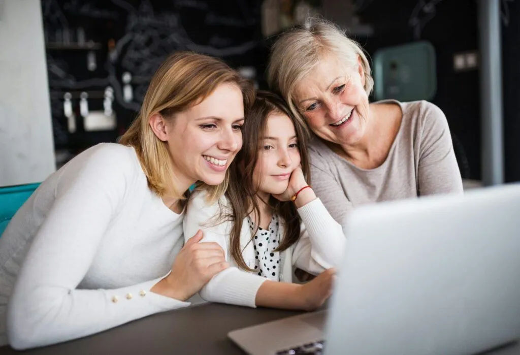Three generations of a family smiling at old photos together